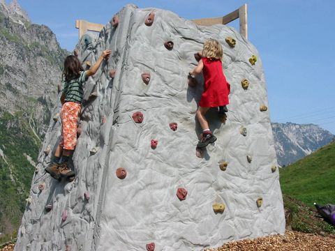 Zwei Kinder klettern am Kleterfels auf dem Erlebnisweg Grimmimutz im Naturpark Diemtigtal