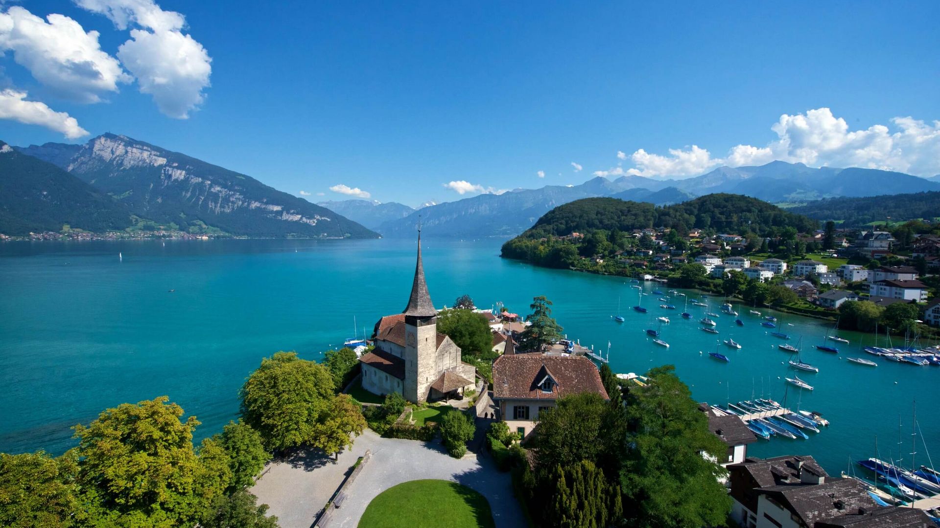 Blick vom Schlossturm auf die Schlosskirche in der Spiezer Bucht am blauen Thunersee
