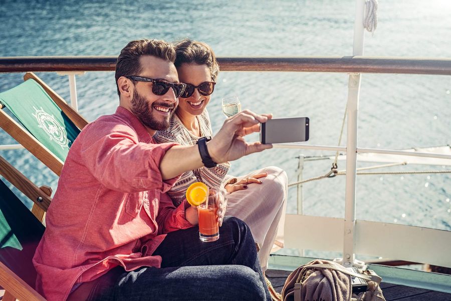 Junges Paar schiesst auf Deck ein Selfie während der Schifffahrt.