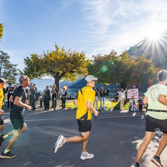 Läufer unterwegs in Bönigen, flankiert von Musik und Zuschauern.