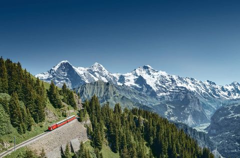 Die Schynige Platte Bahn auf dem Weg zum Gipfel, im Hintergrund das Dreigestirn Eiger, Mönch und Jungfrau