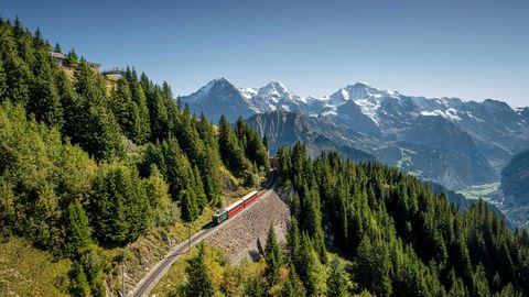 Die Schynige Platte Bahn auf dem Weg zum Gipfel, im Hintergrund das Dreigestirn Eiger, Mönch und Jungfrau